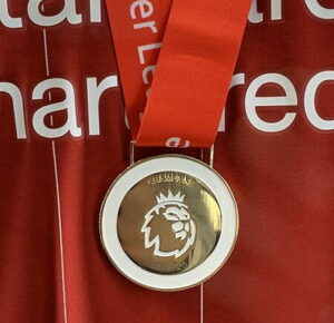 liverpool shirt with 2019-20 premier league medal close up