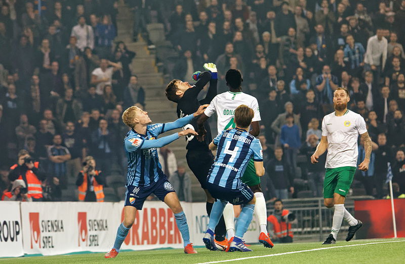 keeper and players all go for the ball heading in football